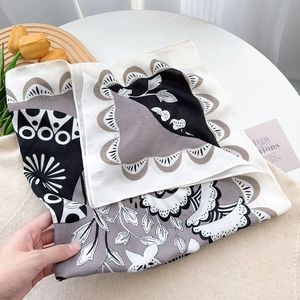 Macro view of silky square scarf featuring vintage floral and geometric patterns