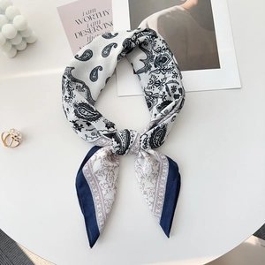 Detailansicht eines marineblauen Seidenschals mit Paisley-Muster und Luxus-Accessoires