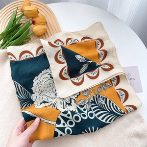 Detail of silk scarf showing floral patterns and elegant drapery on a textured surface