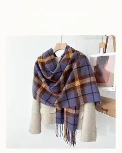 Detail of purple and brown plaid cashmere-like scarf featuring long fringes on a beige coat
