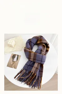 Detail of soft cashmere-like scarf with colorful plaid patterns and long fringe tassels