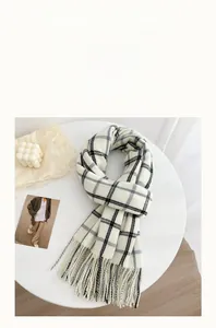 Detail of classic black and white plaid scarf featuring soft cashmere texture and tassels