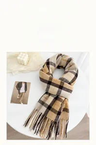 Detail of British plaid winter scarf featuring soft faux cashmere texture and tassels