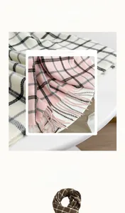Detail of thick cashmere-like plaid scarves with fringe edges in pink and brown patterns