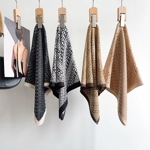 Detail showing four herringbone pattern silk scarves with geometric and floral prints
