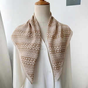 Detail showing beige herringbone scarf with brown floral patterns on a mannequin