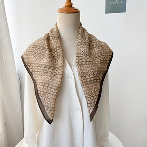 Detail of herringbone silk-feel scarf with vintage floral print tied on white shirt collar