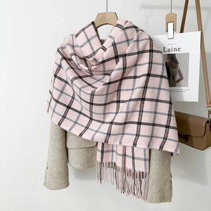 Detail of pink plaid scarf with black and gray checks and long fringes on beige coat