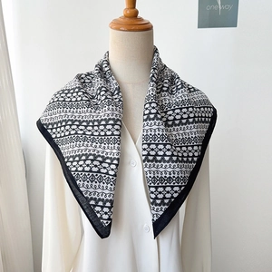 Detailed close-up of herringbone pattern square scarf on white shirt and hanger