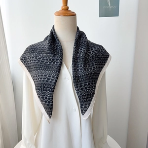 Detailed view of black and white herringbone silk scarf styled with a white shirt