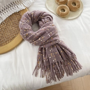 Close-up of thick purple plaid scarf with soft fringe detail and woven texture