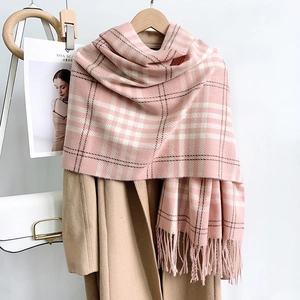 Pink and white plaid cashmere-feel scarf with fringes on a camel wool coat