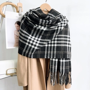 Detailed view of heavy plaid cashmere feel scarf with fringe tassels on beige coat