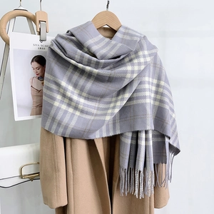 Close-up of grey and beige plaid scarf with soft fringe details on a stylish coat