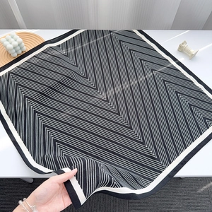 Detailed view of striped silk scarf texture and modern black white geometric patterns