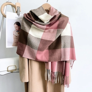 Gros plan d'une écharpe à carreaux doux avec motifs rose et marron et détails de franges