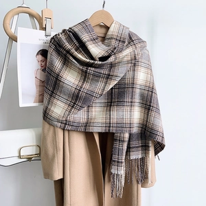 Detail of premium plaid scarf with earth-tone checkered pattern and long fringe tassels