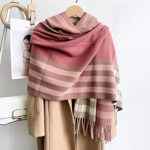 Gros plan d'une écharpe épaisse à carreaux rose et marron avec franges sur manteau
