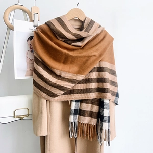 Détail de l'écharpe épaisse à carreaux avec franges assortie à un manteau en laine