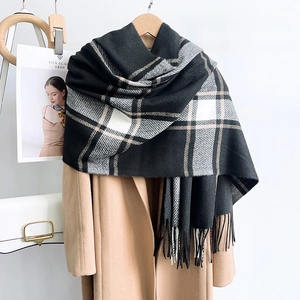 Classic black and white checkered scarf with tassels styled over a wool coat for winter