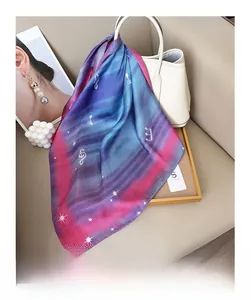 Detail of gradient blue and pink silk scarf with musical note patterns on a white handbag