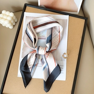 Foulard en soie chic aux motifs géométriques et pied-de-poule sur plateau bois