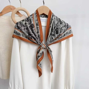 Vintage carriage print silk scarf in light grey and orange tied on a white shirt