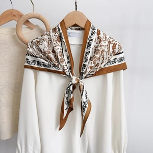 Elegant silk scarf with horse carriage print tied on a white shirt with a wooden hanger
