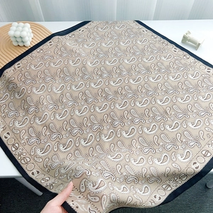 Detailed macro shot of the paisley silk scarf with sateen finish and navy border