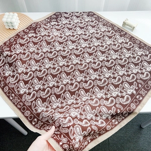 Detailed macro view of brown paisley pattern and silk texture on the fashion square scarf