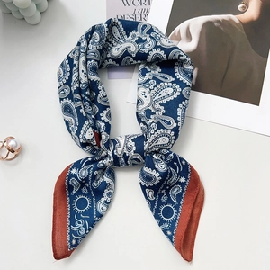 Detailed close-up of navy blue paisley silk scarf with burgundy edges and silky texture