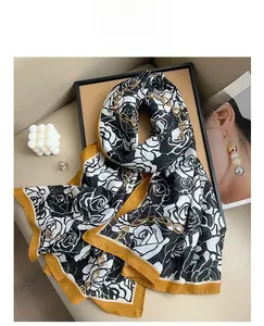 Detail of floral silk scarf with black white roses and golden chain pattern print