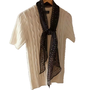 French style black and white polka dot silk scarf paired with white cable knit sweater