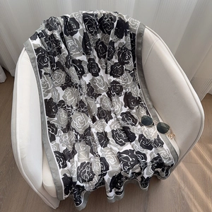 Detail of floral and chain pattern on large winter shawl draped over a chair