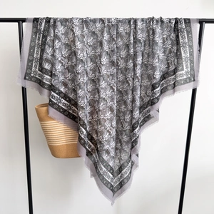 Detail of grey thistle floral pattern scarf with soft fringe edges and woven texture