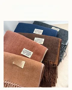 Close-up of soft cashmere-feel fringe scarves in various solid colors for winter