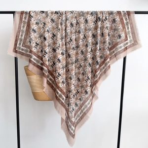 Detailed close-up of retro floral thistle shawl with frayed edges and draped texture
