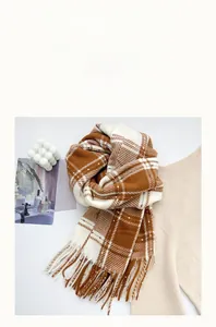 Détails de la texture d'une écharpe à carreaux épaisse en caramel et beige avec franges