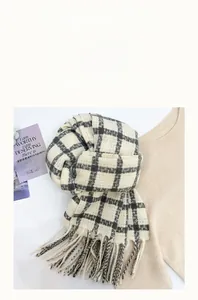 Close-up of soft cashmere-like checkered scarf with fringe details and woven texture