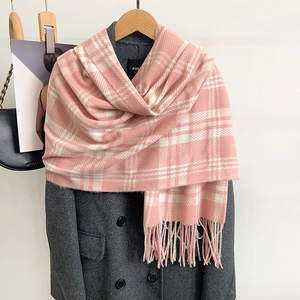 Pink and white plaid cashmere-like scarf with long tassels on a grey wool coat