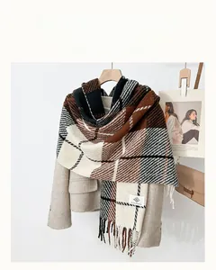 Detail of plaid wool scarf with fringe on wooden hanger against a beige coat