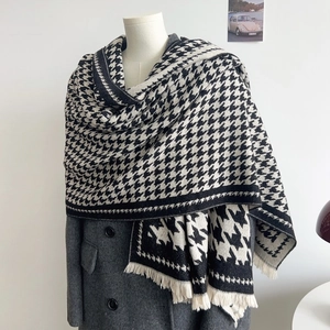 Thick houndstooth wool-like scarf for women with elegant tassel edge on a model