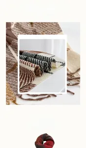 Close-up of the soft cashmere-like texture and fringed edges of a plaid winter scarf