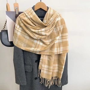 Detail of yellow and white plaid scarf with soft fringe and premium cashmere-like texture