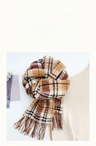 Close-up of ginger plaid cashmere-like scarf with fringe tassels and soft texture