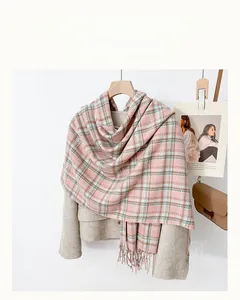 Detail of plaid scarf texture with tassels hanging on a hanger for autumn and winter