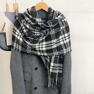 Classic black and white plaid scarf with long tassels paired with a grey wool coat