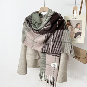 Detail of soft checkered scarf showing thick knit texture and fringe on wool coat