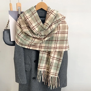 Soft checkered scarf in khaki and green with tassels on gray coat display