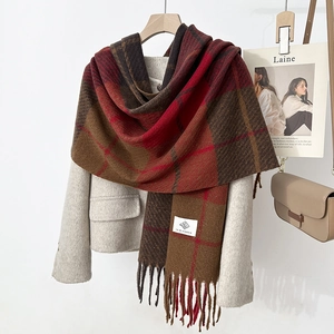 Detailed view of checkered wool scarf with fringes and woven brand label on coat